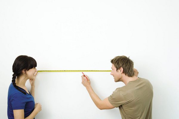 Couple measuring a wall