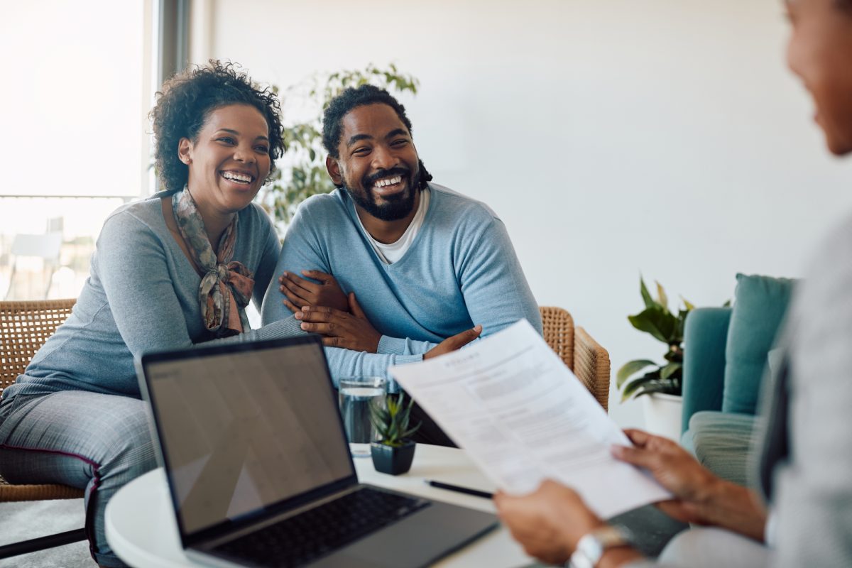 Couple smiling while talking to broker