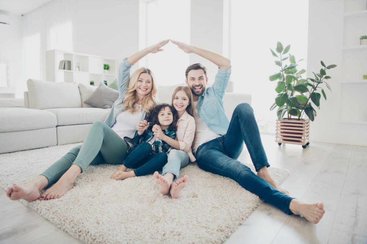 Smiling Parents with their two smiling children in a modern living room
