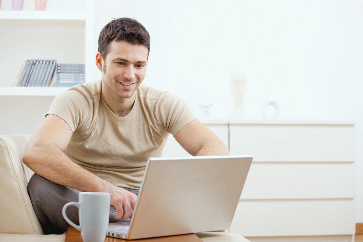 Smiling person sat using a laptop
